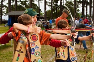 two boys and dad shooting archery